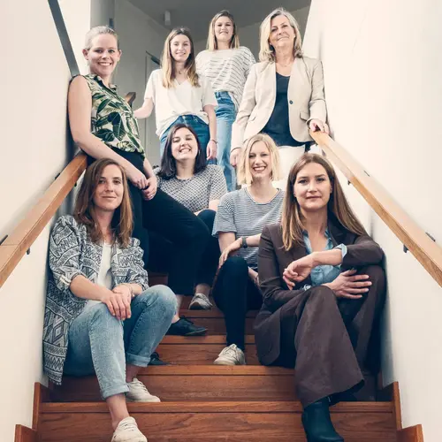 Das RAUMPERLE-Team sitzt auf einer Treppe.