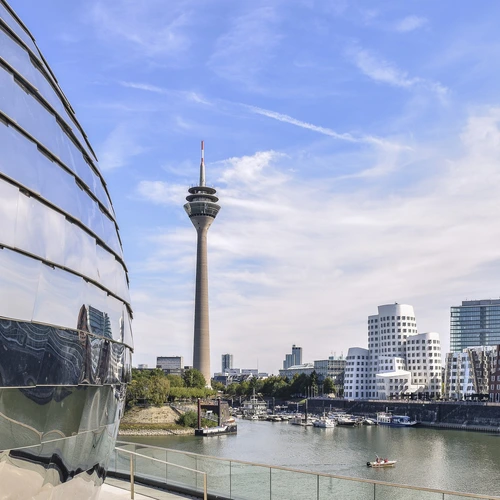Düsseldorf Düsseldorfer Fernsehturm und Medienhafen bei Tag mit blauen Himmel. Reflexion im Gebäude
